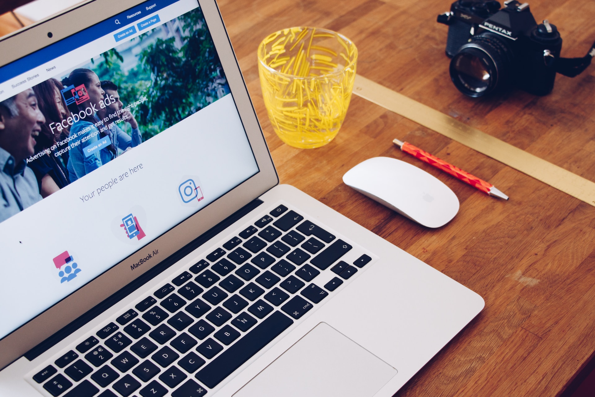 Facebook ads opened on a laptop, next to a camera