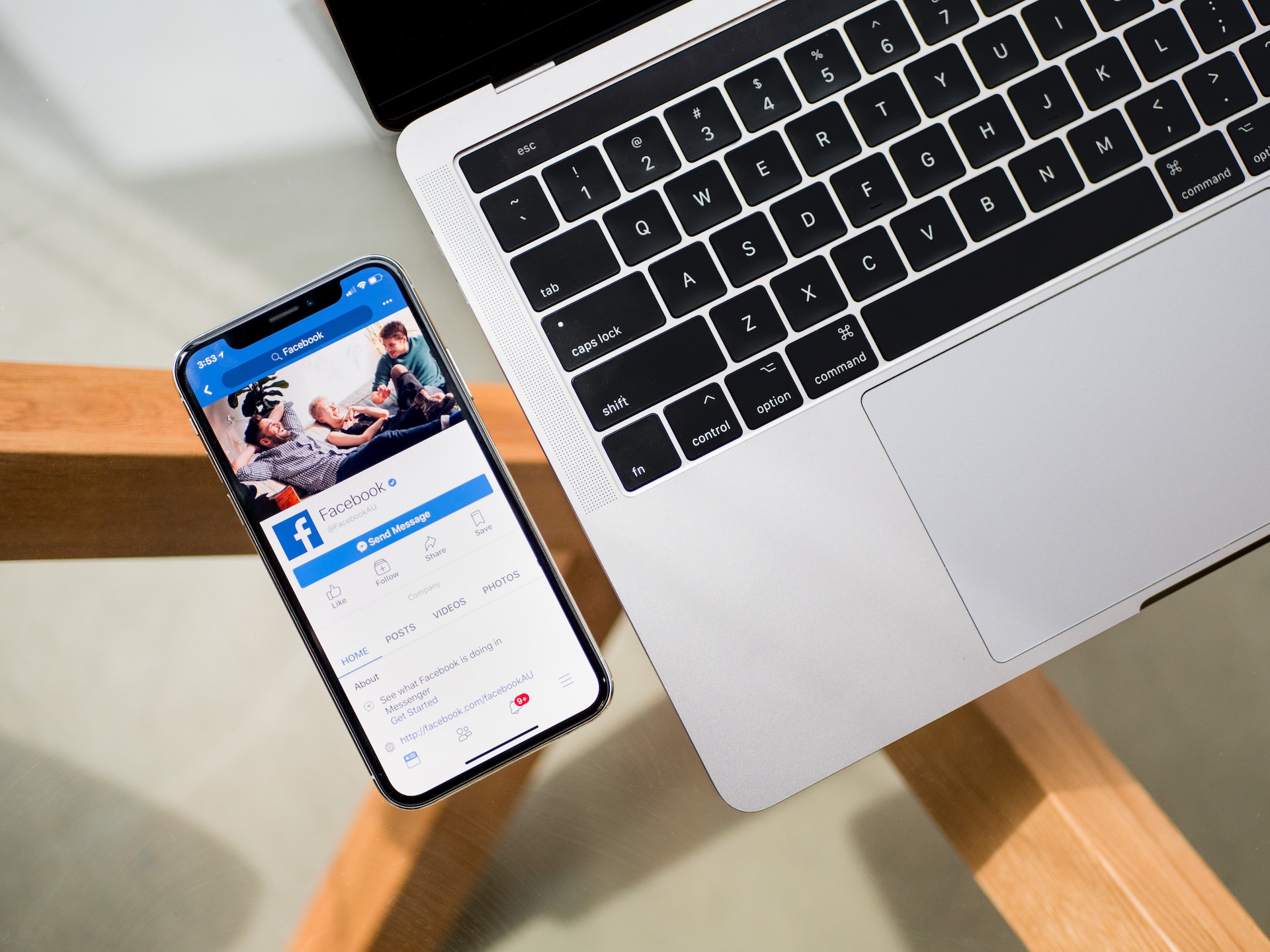 Facebook app running on a smartphone next to a laptop